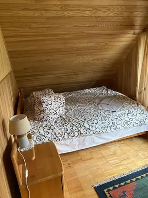 a bedroom with a bed in a wooden room at Šeimyninis namelis nr.1 in Kurėnai