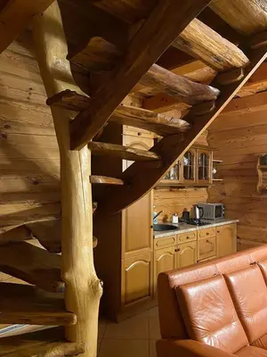 a kitchen with a wooden staircase in a cabin at Šeimyninis namelis nr.1 in Kurėnai