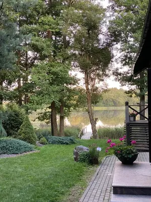 a garden with a bench and a body of water at Šeimyninis namelis nr.1 in Kurėnai