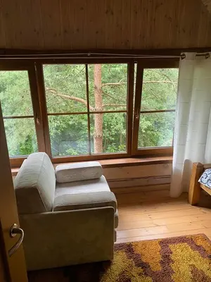 a living room with a couch and large windows at Šeimyninis namelis nr.2 in Kurėnai