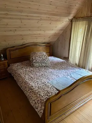 a bedroom with a bed in a log cabin at Šeimyninis namelis nr.2 in Kurėnai