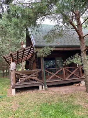 a log cabin with a porch and a tree at Šeimyninis namelis nr.2 in Kurėnai