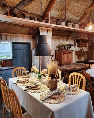 a table with a white table cloth and a black lamp at Vienkiemio Oazė - Autentiškas Kluonas in Galvokai