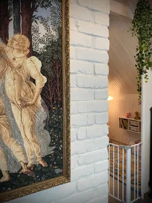 a painting of a woman on a wall at Namelis prie Širvintos upės su pirtimi in Širvintos