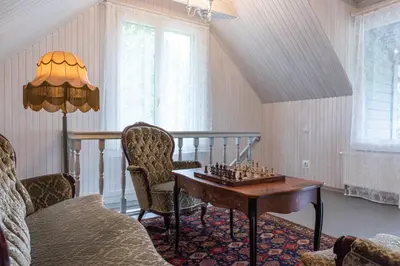 a living room with a chess board on a table at Namelis prie Širvintos upės su pirtimi in Širvintos