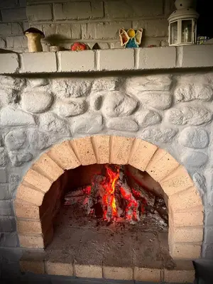 a brick oven with a fire inside of it at Namelis prie Širvintos upės su pirtimi in Širvintos