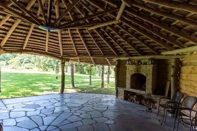 an outdoor patio with a brick fireplace and chairs at Namelis prie Širvintos upės su pirtimi in Širvintos