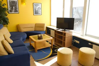 a living room with a blue couch and a tv at Laisvės 50D in Kaunas