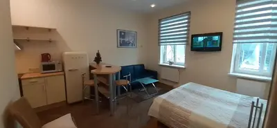 a room with a bed and a table and a television at Laisvės 50D in Kaunas
