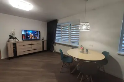 a living room with a table and a tv at Cozy stay in unique town - Kėdainiai in Kėdainiai