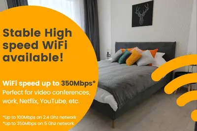 a bedroom with a bed with a yellow sign that reads stable high speed wifi available at Comfy 2 Room Apartment - Free Parking - 350Mbps WiFi - Netflix in Kaunas
