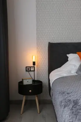 a bedroom with a bed and a night stand with a lamp at Comfy 2 Room Apartment - Free Parking - 350Mbps WiFi - Netflix in Kaunas