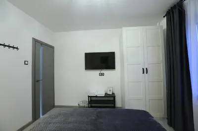 a bedroom with a bed and a tv on the wall at Comfy 2 Room Apartment - Free Parking - 350Mbps WiFi - Netflix in Kaunas