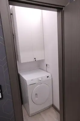 a bathroom with a toilet with a cabinet above it at Comfy 2 Room Apartment - Free Parking - 350Mbps WiFi - Netflix in Kaunas