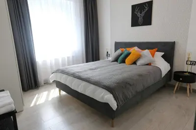 a bedroom with a bed with colorful pillows on it at Comfy 2 Room Apartment - Free Parking - 350Mbps WiFi - Netflix in Kaunas