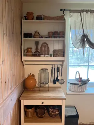 a shelf with utensils on it in a kitchen at Peledos troba in Žiūrai