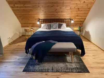 a bedroom with a large bed and a wooden ceiling at Peledos troba in Žiūrai