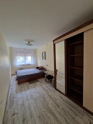 a bedroom with a bed and a wooden floor at Lima C in Druskininkai