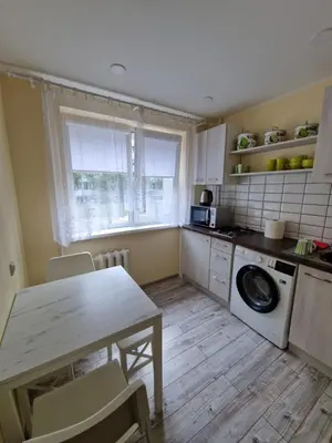 a kitchen with a table and a washing machine at Lima C in Druskininkai