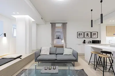 a living room with a couch and a kitchen at Buddha Luxury Apartment Kaunas city centre in Kaunas