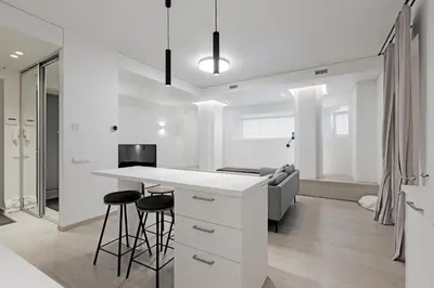 a kitchen and living room with a counter and stools at Buddha Luxury Apartment Kaunas city centre in Kaunas