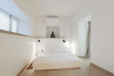 a bedroom with a bed in a white room at Buddha Luxury Apartment Kaunas city centre in Kaunas