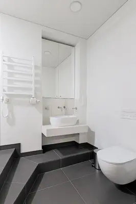 a white bathroom with a toilet and a sink at Buddha Luxury Apartment Kaunas city centre in Kaunas