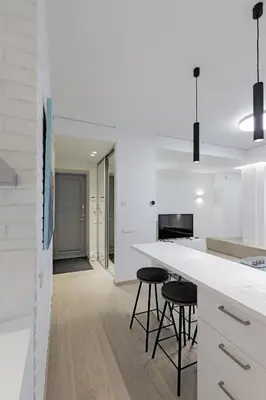 a kitchen with a white counter top and stools at Buddha Luxury Apartment Kaunas city centre in Kaunas