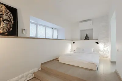 a bedroom with a bed and a painting on the wall at Buddha Luxury Apartment Kaunas city centre in Kaunas