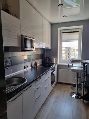 a kitchen with white cabinets and a sink and a window at Pas Romaną in Zarasai