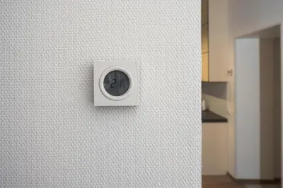 a white clock on a wall in a room at Laurentroom Central Park in Ukmergė