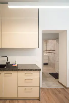 a kitchen with white cabinets and a counter top at Laurentroom Central Park in Ukmergė