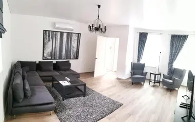 a living room with a couch and a table and chairs at Laurentroom Central Park in Ukmergė