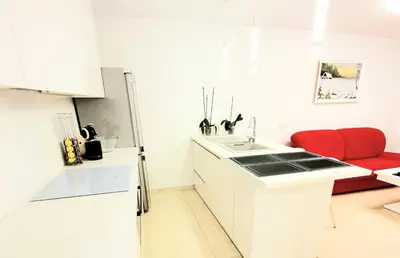 a kitchen with a white refrigerator and a red chair at Home sweet home in Radviliškis