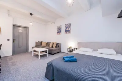 a white bedroom with a bed and a couch at The house black in Vilnius
