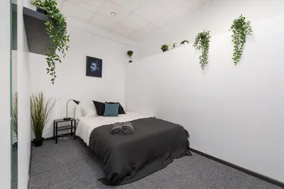 a bedroom with a bed and plants on the wall at The house black in Vilnius