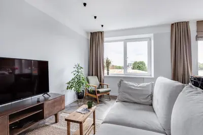 a living room with a couch and a flat screen tv at Old-New Apartment in Central Kaunas in Kaunas