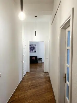 an empty hallway with white walls and wood floors at Old Town home of Evil Dog in Vilnius