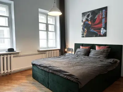 a bedroom with a green bed with a poster on the wall at Old Town home of Evil Dog in Vilnius