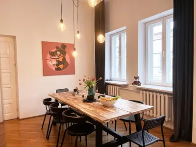 a dining room with a wooden table and chairs at Old Town home of Evil Dog in Vilnius