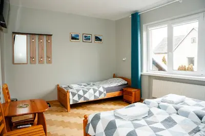 a bedroom with two beds and a window at Alma B&B in Kalvarija