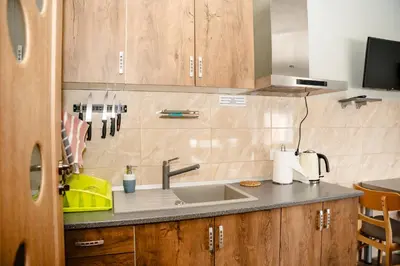a kitchen with a sink and wooden cabinets at Alma B&B in Kalvarija