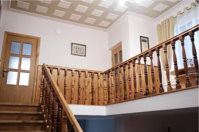 a wooden staircase in a house with a window at Alma B&B in Kalvarija