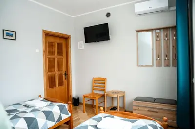 a bedroom with two beds and a tv on the wall at Alma B&B in Kalvarija