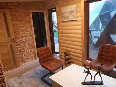 two chairs and a table in a room with windows at kupolas in Šiauliai