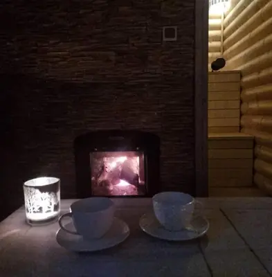 two cups and saucers on a table in front of a fireplace at kupolas in Šiauliai