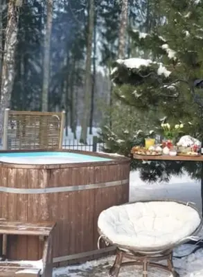 a hot tub and a chair in the snow at kupolas in Šiauliai