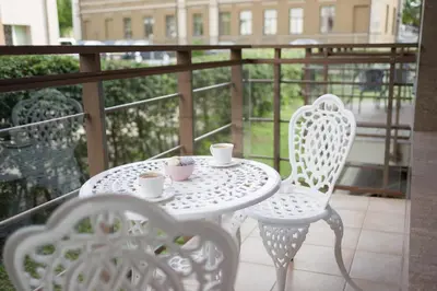 a white table and chairs on a balcony at Liepų Apartments in Druskininkai
