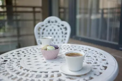 a table with two cups of coffee and a bowl of cookies at Liepų Apartments in Druskininkai