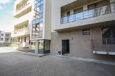 a large brick building with a door in a courtyard at Liepų Apartments in Druskininkai